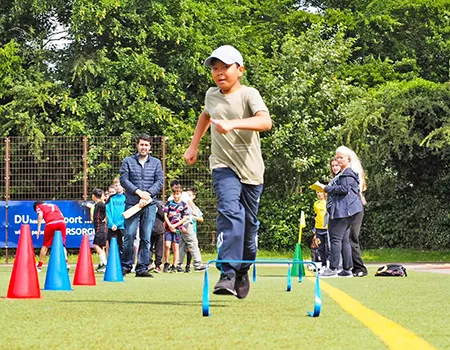 Ein Junge absolviert eine Laufdisziplin beim Sportfest
