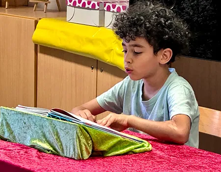 Junge liest aus einem Buch vor