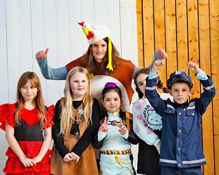 Kinder und Lehrerin verkleidet auf der Karnevalsfeier der Schule