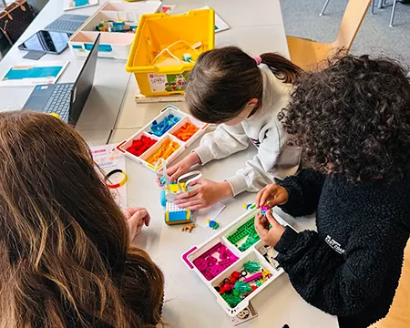 Kinder im Medienzentrum probieren am Tisch Bots aus
