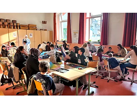 Eltern und Kinder beim Laternenbau im Klassenraum